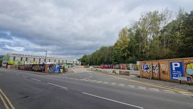 Pay & Display car park on Boyland Street, surrounded by colorful graffiti and trees under a cloudy sky.