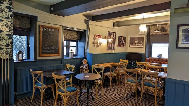 Cozy bar interior with wooden tables, chairs, a chalkboard menu, and vintage decor in Riddlesden, Yorkshire.