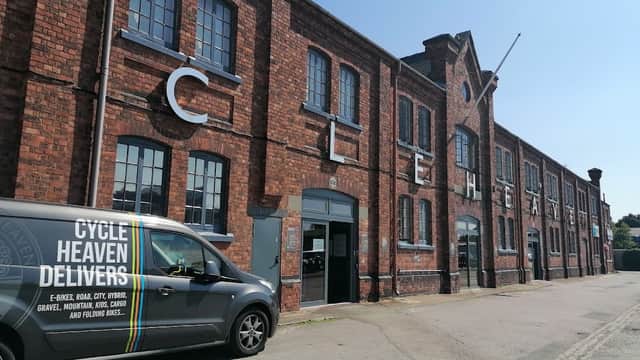Brick building with large letters spelling "CYCLE HEAVEN," featuring a delivery van parked outside.