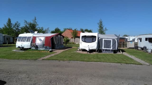 Caravans set on a grassy area with trees and blue sky at Hundred Oaks Caravan Park, Sutton upon Derwent.