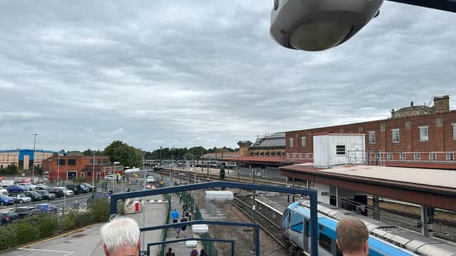 York Commuter Car Park with parked cars, train tracks, and a cloudy sky in the background.