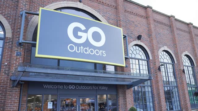 Large "GO Outdoors" sign on a brick building with arched windows, welcoming customers to the sports shop.