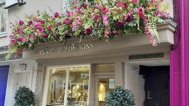Jewellers shop "Werk" in York with floral display, two potted trees, and elegant window showcasing jewelry.