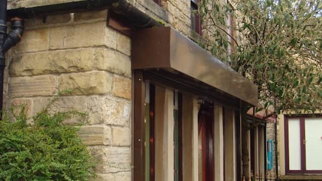 Aura Jewellery storefront with a blue sign, stone walls, and a small tree outside in Otley, Yorkshire.