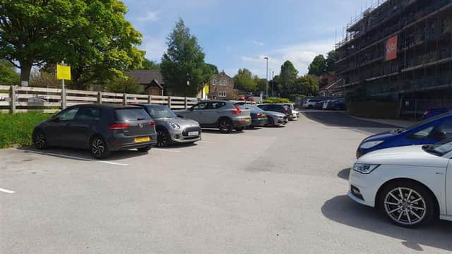 Pannal Village Hall car park with parked cars, greenery, and a building under construction in the background.