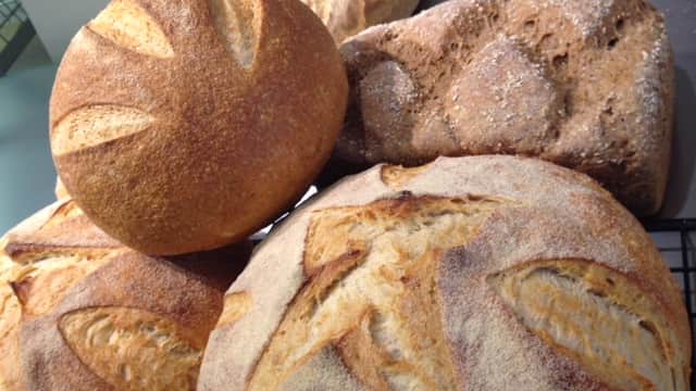 Freshly baked artisan breads with golden crusts, displayed on a cooling rack at Bondgate Bakery in Otley, Yorkshire.