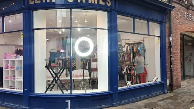 Lehi James Limited storefront with blue trim, displays sports gear, and a circular light in the window.