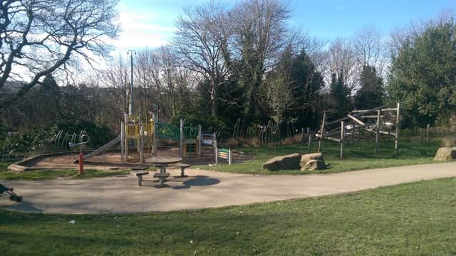 Playground with slides and climbing structures, surrounded by trees and a grassy area in Chapeltown Park, Yorkshire.