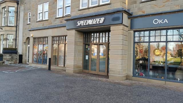 Specialized Concept Store in Harrogate features a stone facade, large windows, and a neighboring shop, Oka.