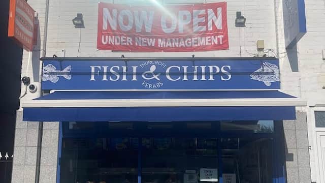Brightly colored storefront of Thurcroft Fish Bar with a "NOW OPEN" banner and a blue awning displaying menu items.