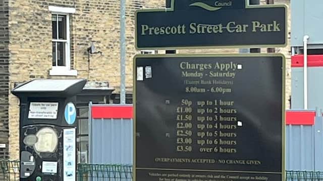 Sign for Prescott Street Car Park with parking charges and instructions, alongside a pay and display machine.