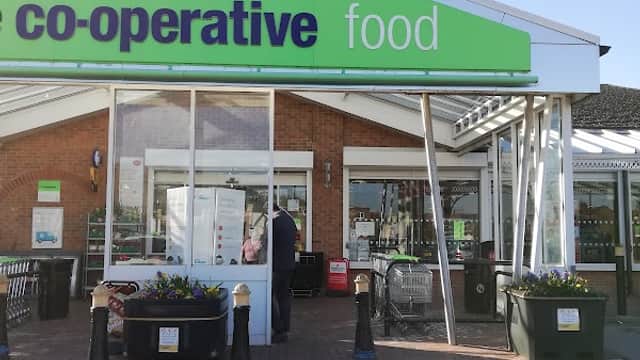 Co-op Food store entrance in Stocksbridge, Yorkshire, with outdoor seating and flower planters.