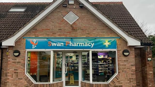 Swan Pharmacy storefront with a blue sign, large windows, and a brick facade in Brayton, North Yorkshire.