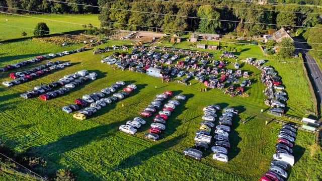 Aerial view of Jawbone Carboot in Oughtibridge, featuring rows of parked cars on a grassy field.