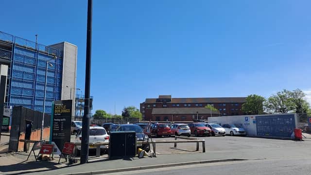 Castle Buildings Car Park with parked cars, clear blue sky, and nearby buildings in Hull, Yorkshire.