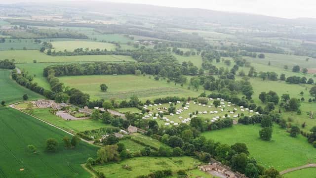 Aerial view of Constable Burton Hall Caravan Park, surrounded by lush green fields and trees in North Yorkshire.