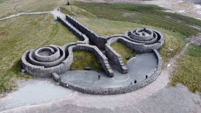 Aerial view of Coldstones Cut, featuring stone structures resembling scissors on a grassy landscape in Bewerley, Yorkshire.