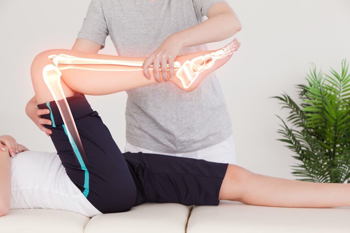Physiotherapist assisting a patient with a knee treatment, showcasing joint movement and anatomical overlay.