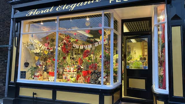 Charming florist shop with vibrant floral displays and decorative signage, showcasing a variety of colorful flowers.