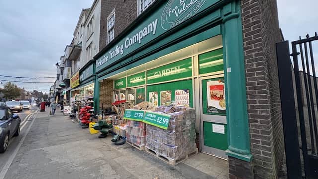 Yorkshire Trading Company storefront with green signage, displays of garden supplies, and a sidewalk with shoppers.