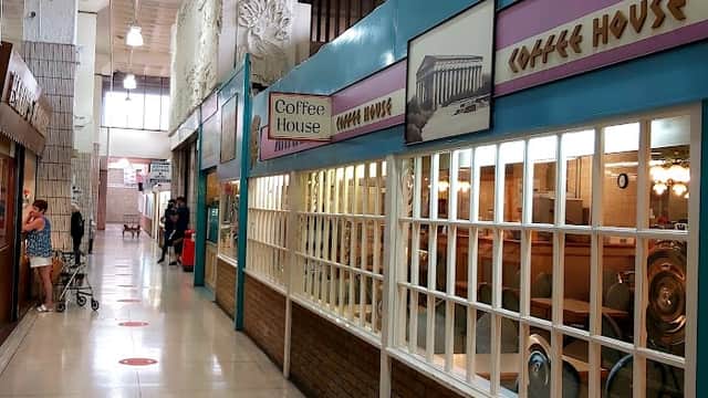 Interior view of Kirkgate Shopping Centre featuring shops, coffee house signage, and shoppers in a spacious hallway.