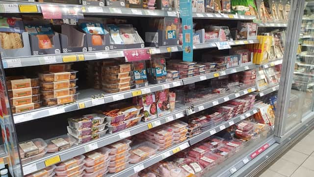 Chilled food aisle at Co-op Food, featuring a variety of packaged meats and ready meals on display.