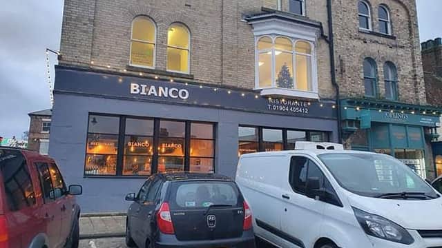 Bianco Ristorante in Thirsk, featuring a festive window display, parked cars, and a charming brick facade.