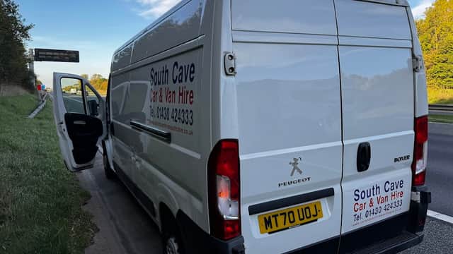 White van with "South Cave Car & Van Hire" branding parked by the road, with an open driver's door.