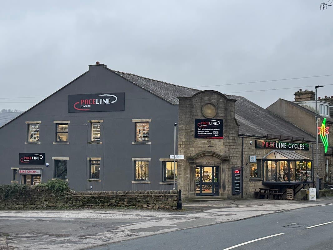 Paceline Cycles shopfront featuring a bike shop and cafΓ©, with signage and a large window display in Cross Hills, Yorkshire.
