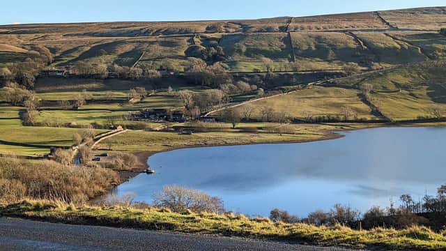 Serene lake reflecting the landscape, surrounded by rolling hills and lush greenery in Semer Water Nature Reserve.