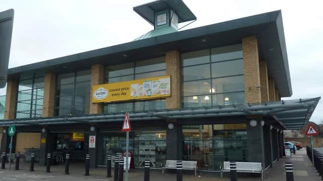 Morrisons supermarket in Barnsley with large glass windows and a prominent yellow banner advertising low prices.