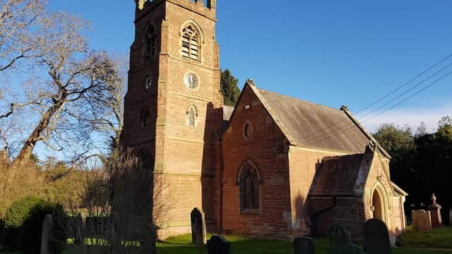 Low Dinsdale Manor features a historic church with a tall clock tower, surrounded by gravestones and greenery.
