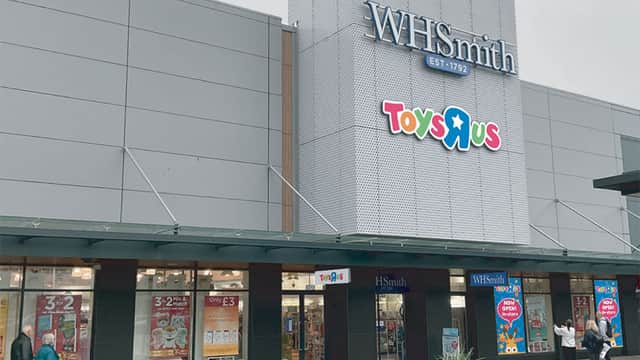 Toys R Us storefront featuring colorful signage, with WHSmith above and promotional posters in windows.