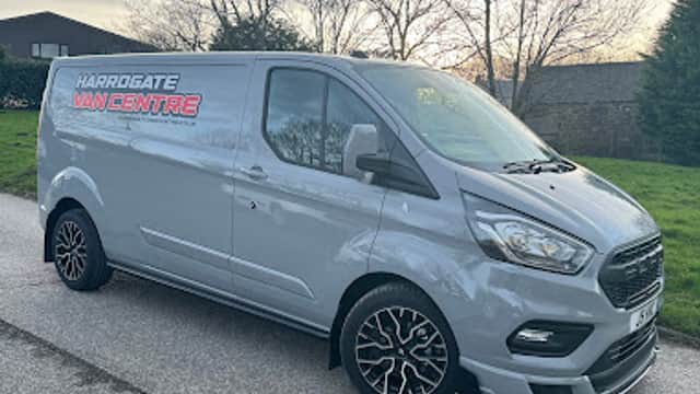 Silver van with "Harrogate Van Centre" branding parked on a road, surrounded by trees and a grassy area.