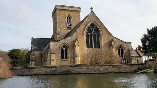 Welton Church with a stone faΓ§ade, tall tower, and surrounding water and trees in Welton, Yorkshire.