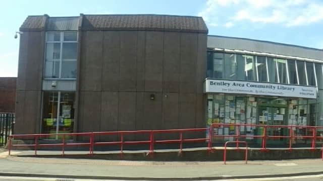 Bentley Area Community Library building with large windows, red railings, and community notices on display.