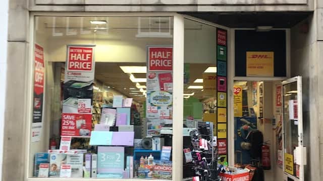 Ryman Stationery storefront with promotional signs, displaying stationery items and a clearance rack outside.