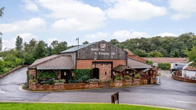 Spital Farm Camping Site & Themed Shopping Centre with rustic buildings, greenery, and a winding driveway in Yorkshire.