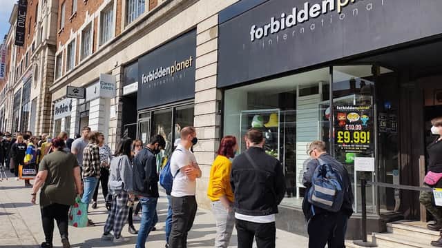 Crowd of people waiting outside Forbidden Planet International bookshop in Leeds, Yorkshire, with storefront signage visible.
