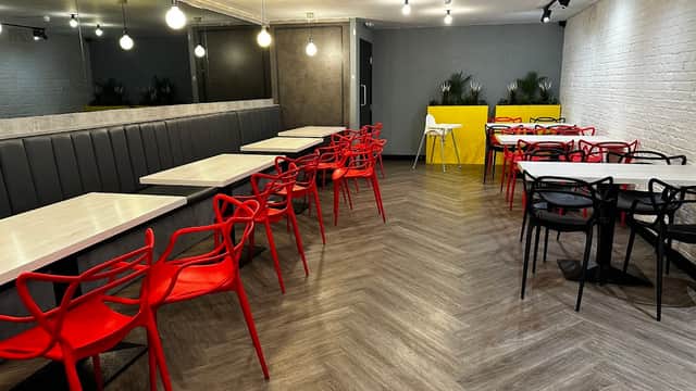 Modern dining area with red and black chairs, wooden tables, and stylish lighting in BrgrBro Batley, Yorkshire.