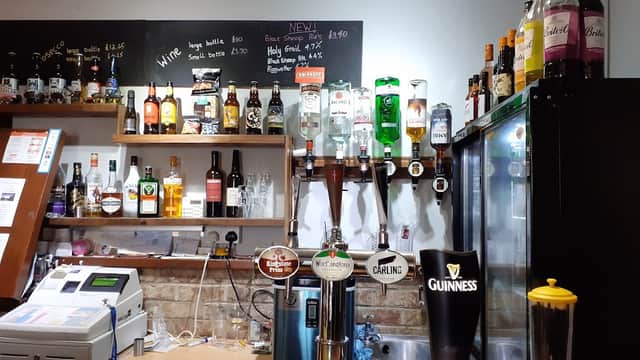 Bar counter with various beer taps, a selection of spirits, and a chalkboard menu at Linton Lock Inn.