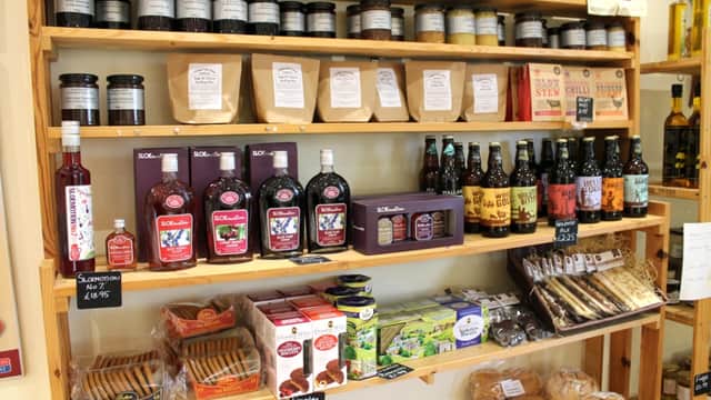 Shelves stocked with jars, bottles, and packaged goods, including jams, biscuits, and drinks at Trotters Farm Shop.
