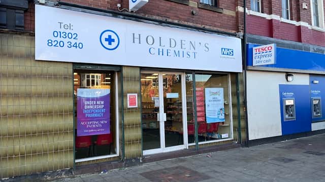 Holden's Chemist storefront in Bentley, featuring a large sign, NHS logo, and promotional posters.