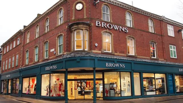 Browns York storefront featuring large windows, red brick exterior, and prominent clock above the entrance.