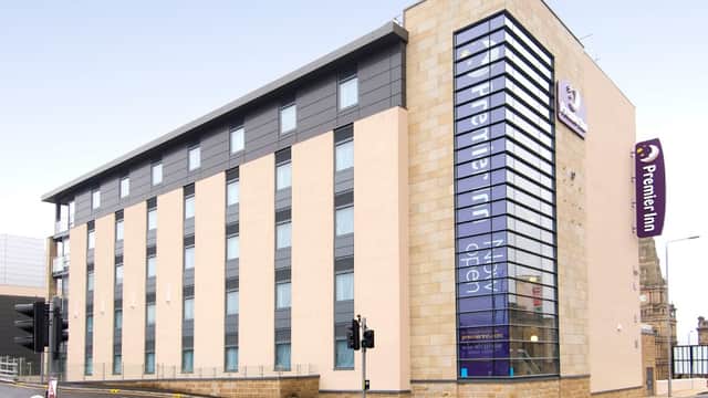 Modern building with large windows, featuring the Premier Inn sign and a pedestrian crossing in Halifax, Yorkshire.