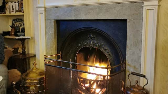 Cozy fireplace with a roaring fire, surrounded by decorative elements and a warm, inviting atmosphere.