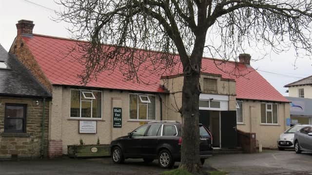 Seamer & Irton Memorial Hall with a red roof, sign reading "Hall for Hire," and surrounding trees and vehicles.