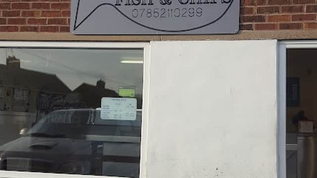 Sign for Byram Fish and Chips on a brick building, featuring a fish graphic and contact number.