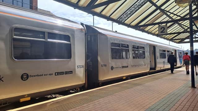 Train at Barnsley station platform, with passengers waiting and a covered roof overhead.