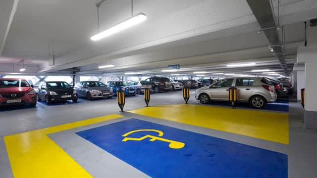 Pay & Display parking area with marked disabled space, cars parked, and bright overhead lighting in Leeds.